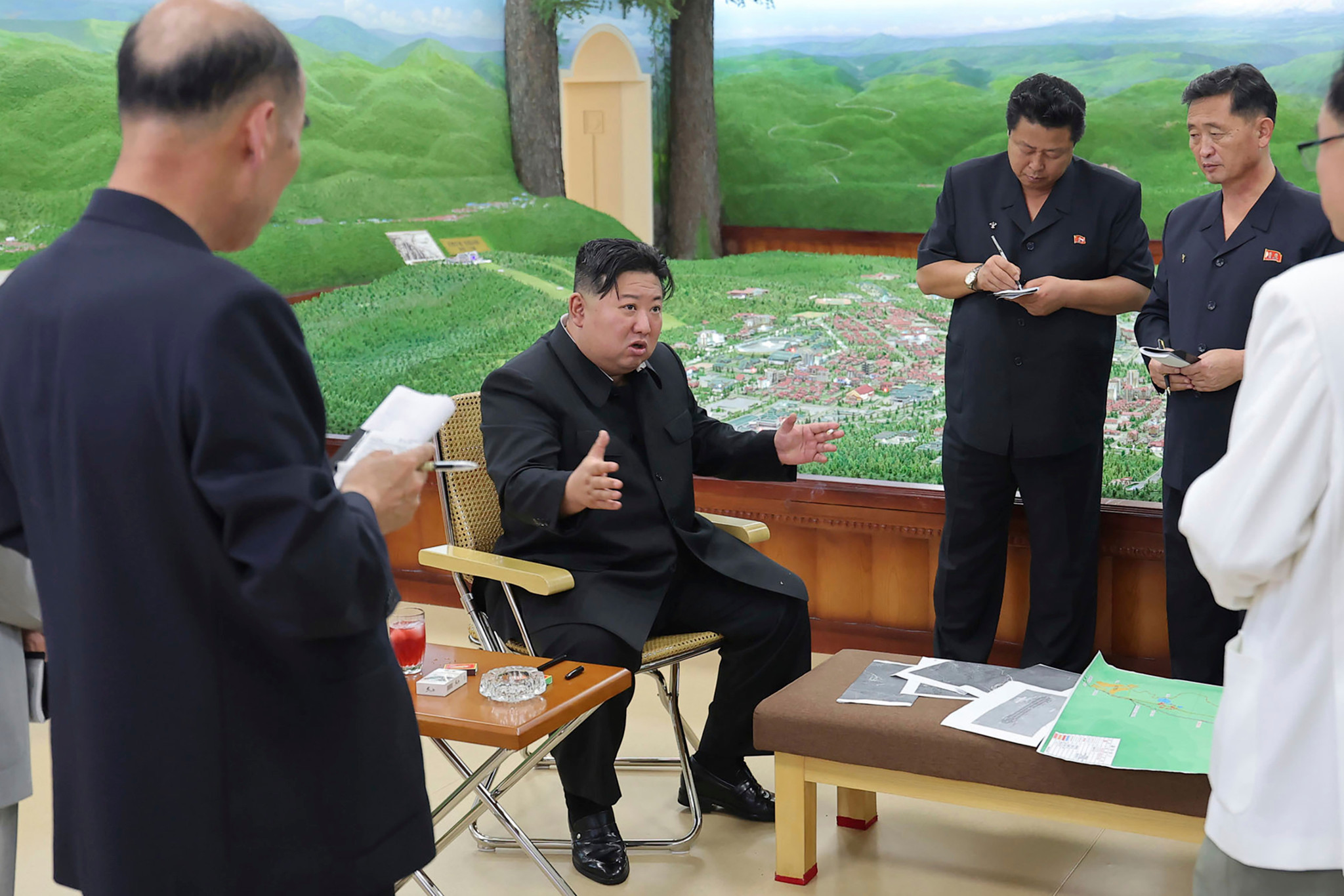 Kim Jong Un, in the center, gesturing while inspecting a development project in Samjiyon, Ryanggang Province. He is surrounded by officials taking notes.